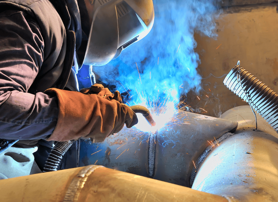 Une personne en train de souder un tuyau en acier